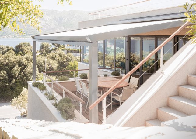 Moderne Terrasse mit Aussicht, Essbereich unter Überdachung und stufenförmiger Gestaltung.